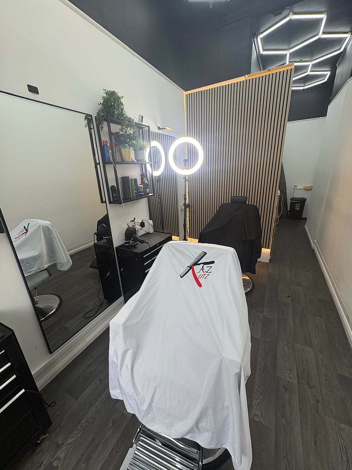 Inside Caliber Barbershop, ring light and Kaz-branded cape