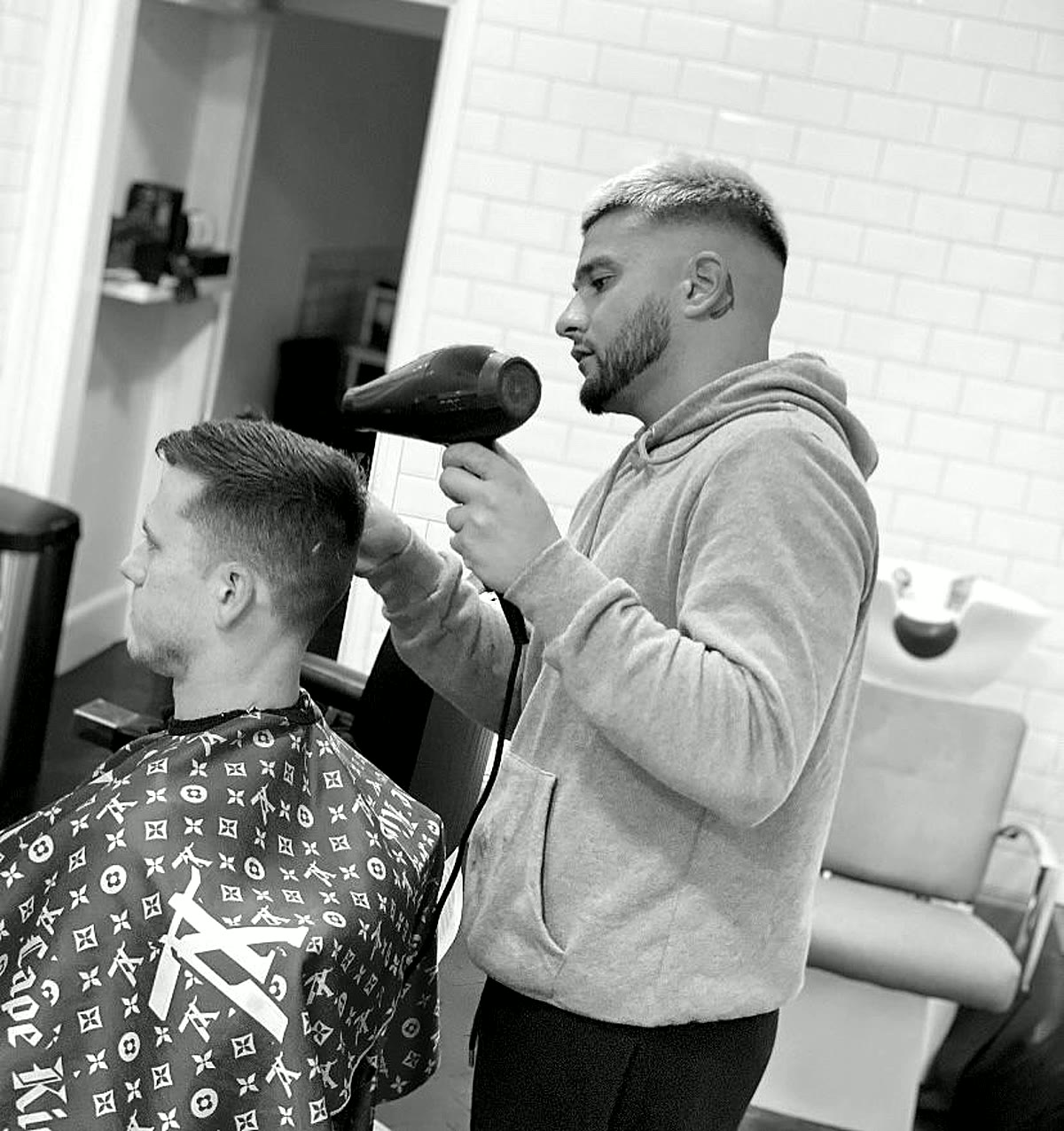Kaz blow-drying a client's hair at Caliber Barbershop, Southbourne